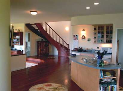 View from the breakfast nook looking through the kitchen to the center of the house. Note the curve of the winding stairway is reflected in the curve of the 'corners' of the walls, and the curved steps down into the living room area.