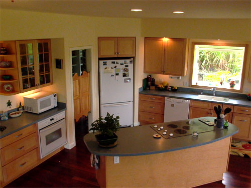 Kitchen design is very important. This cooking island is positioned for maximum ease of flow. Note the refrigerator is 'built-in' to the wall, and the swinging doors to the conveniently located pantry.